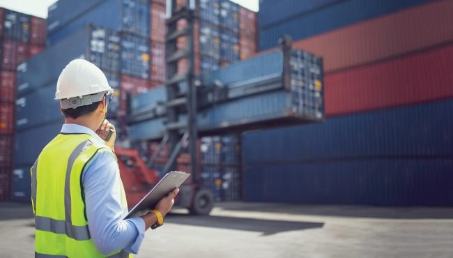 Foreman control loading containers box from cargo freight ship f